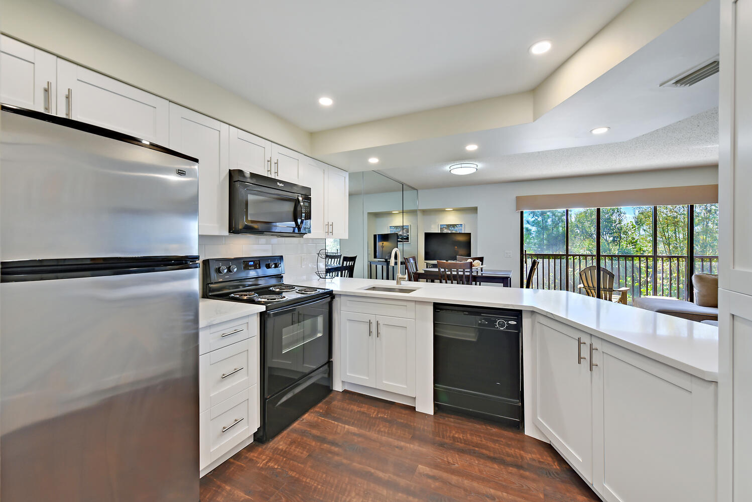 a kitchen with a sink stainless steel appliances cabinets and a window