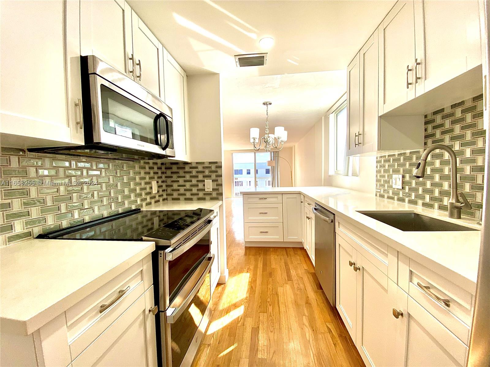 a kitchen with stainless steel appliances a stove a sink and a microwave