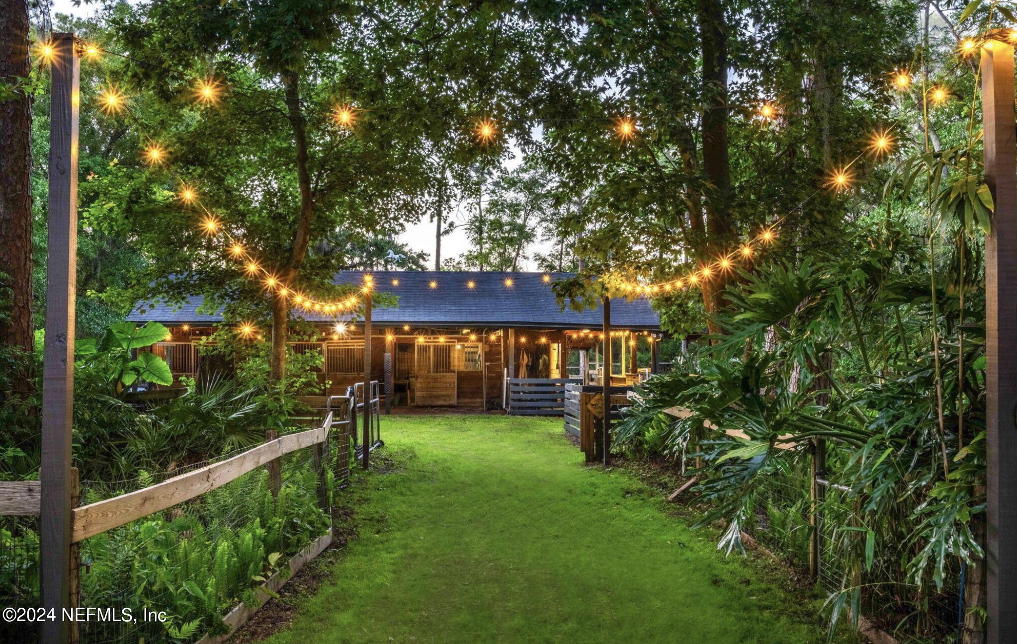 a view of a house with a yard and potted plants