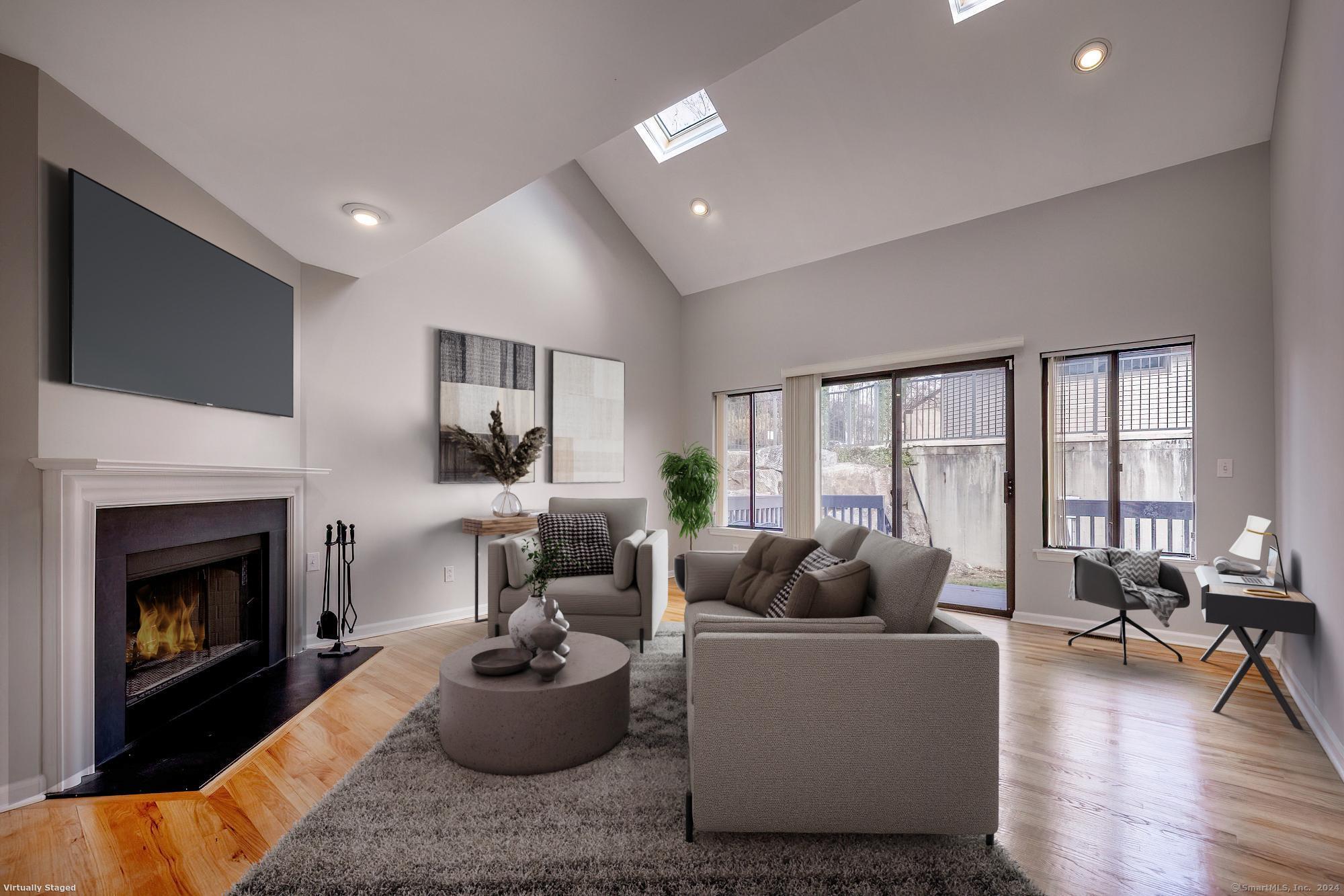 a living room with furniture a fireplace and a floor to ceiling window