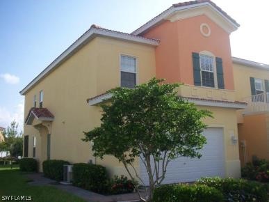 a front view of a house with plants and trees