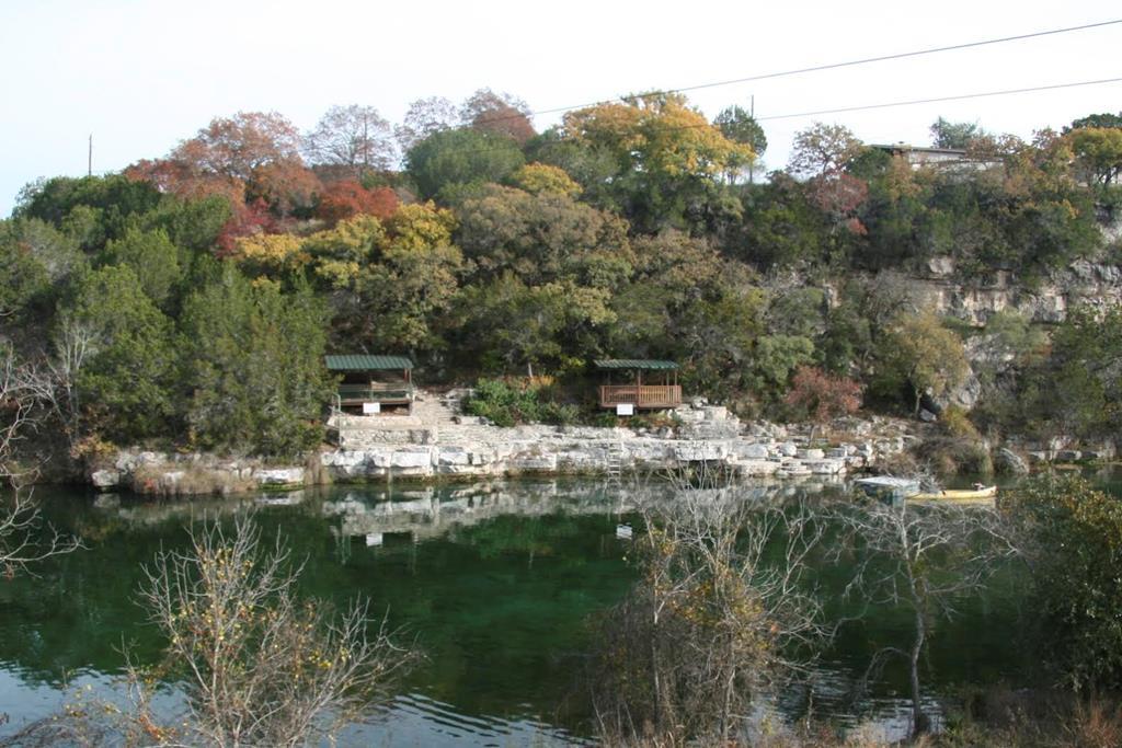 a view of river covered by trees and buildings