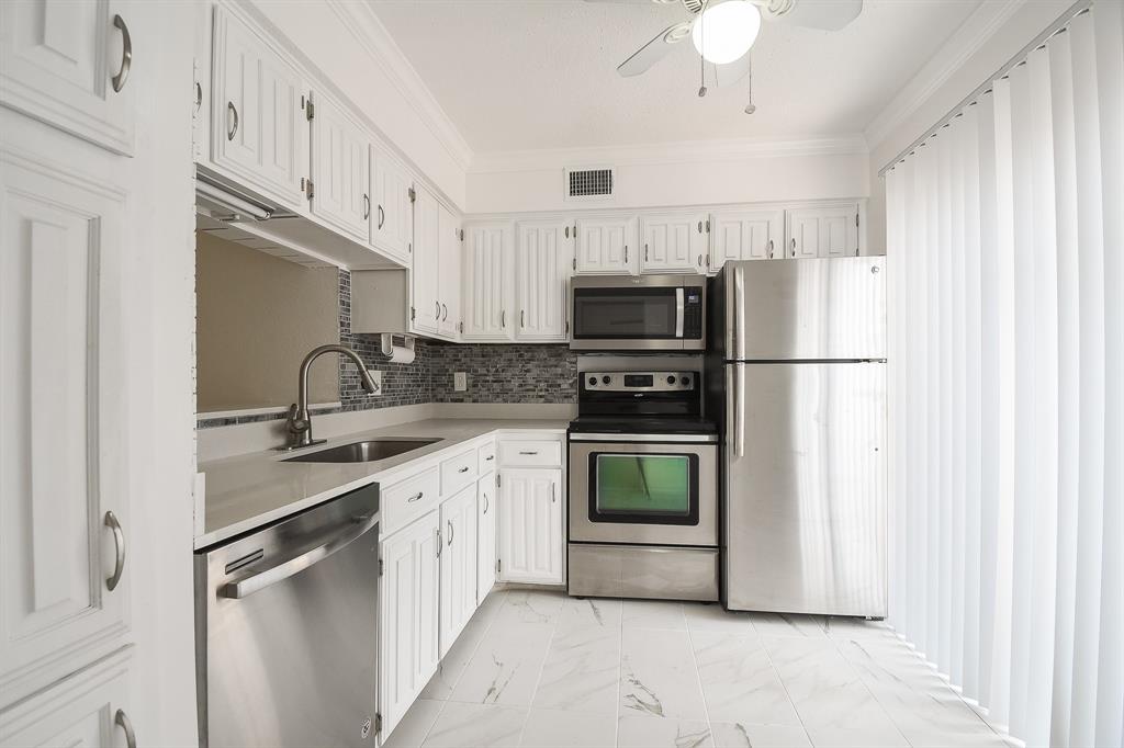 a kitchen with stainless steel appliances a refrigerator sink and cabinets