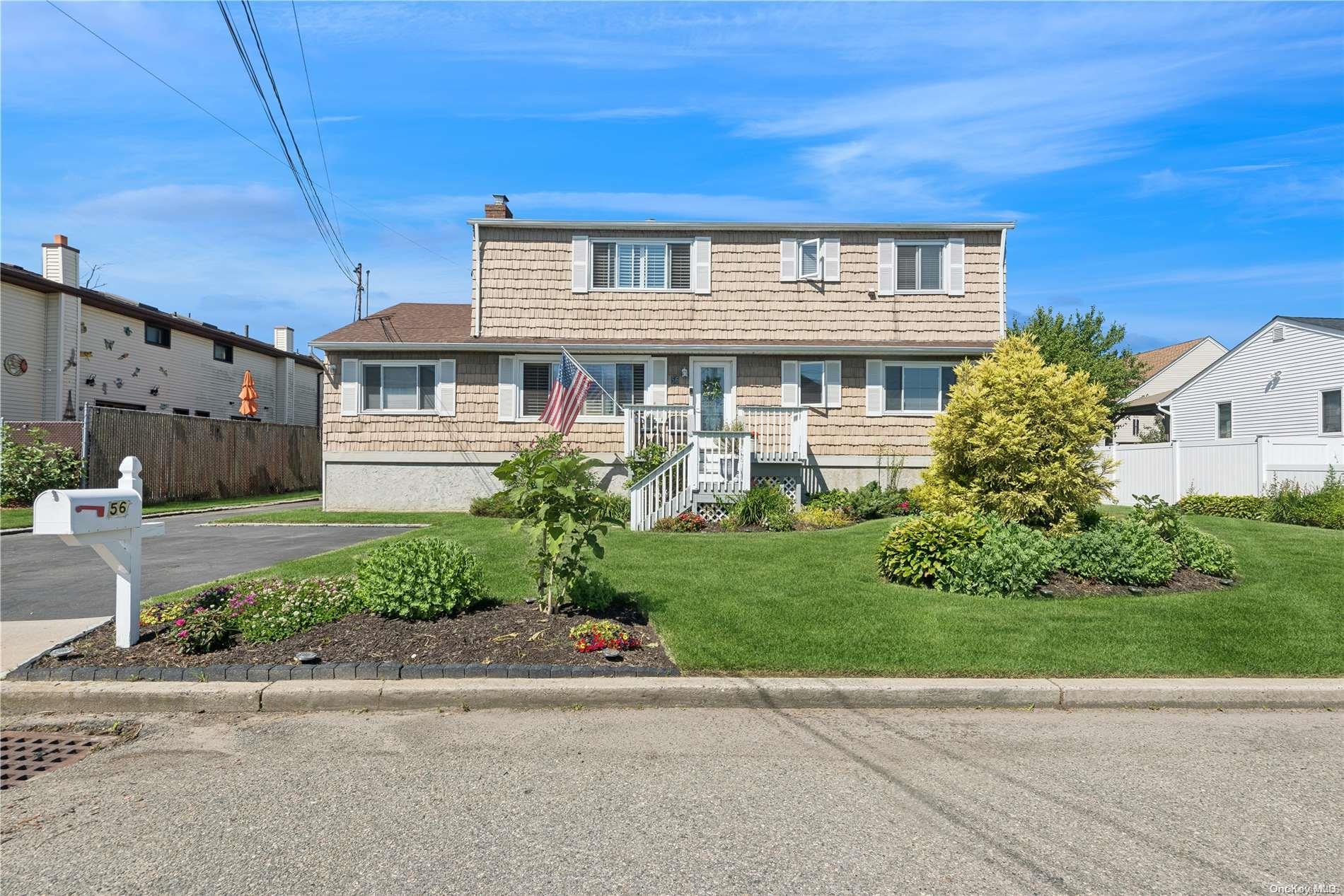 a front view of a house with a yard and potted plants