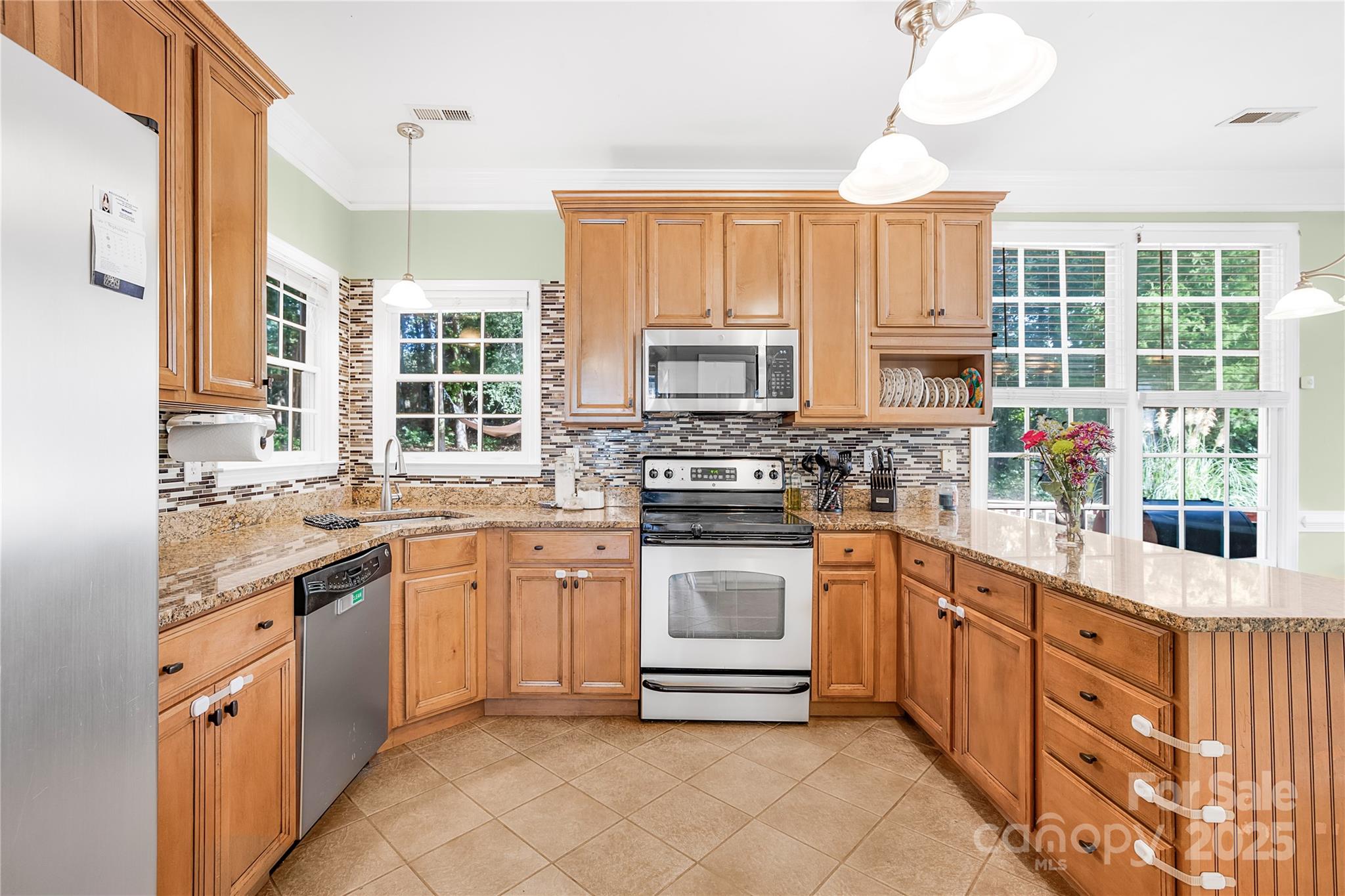 a kitchen with stainless steel appliances granite countertop a stove sink and cabinets