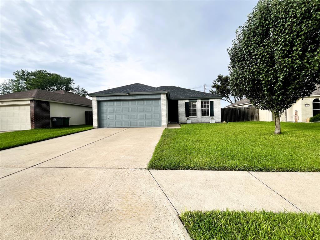 a front view of a house with a garden and trees