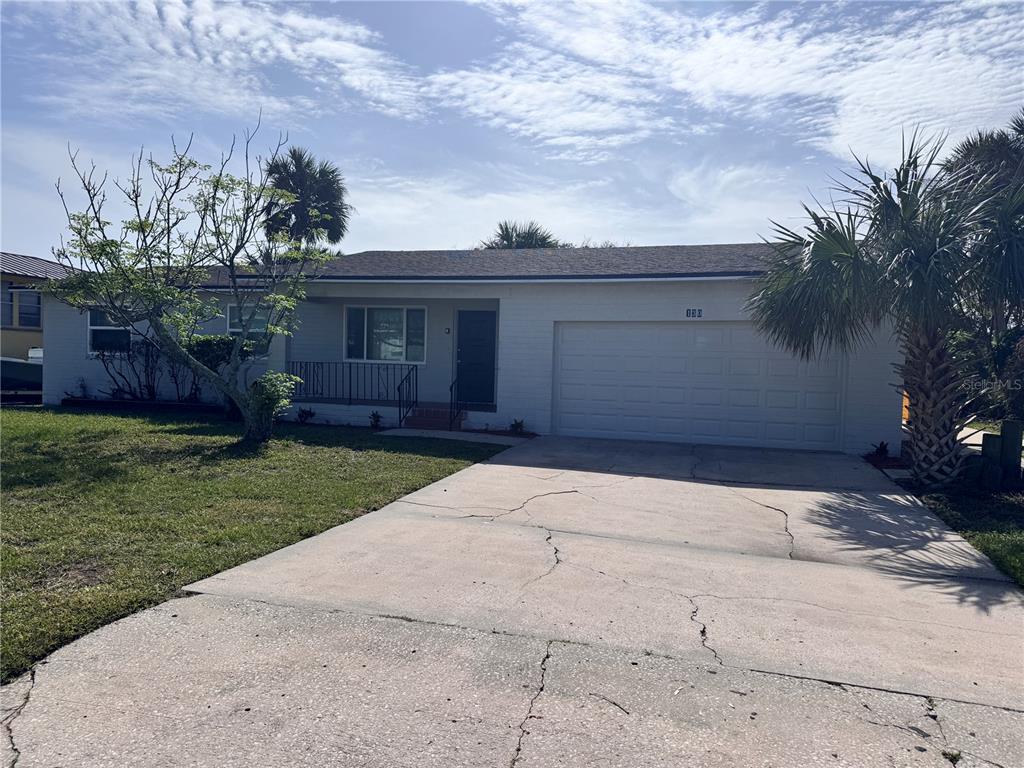 front view of house with a yard and an trees