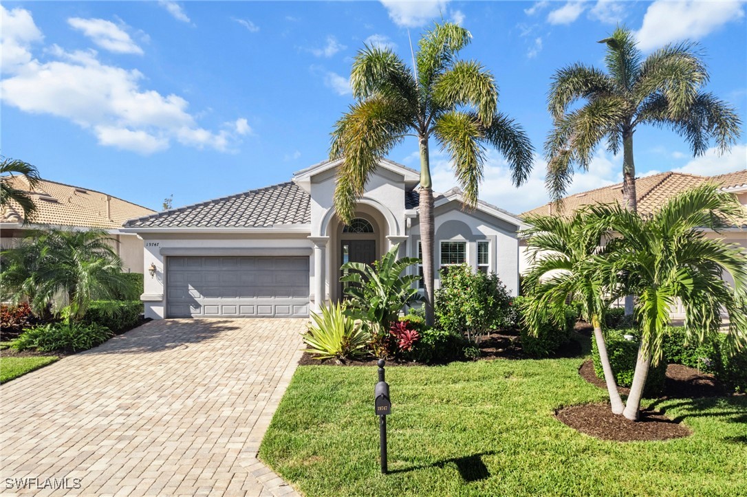 a front view of a house with a yard and potted plants