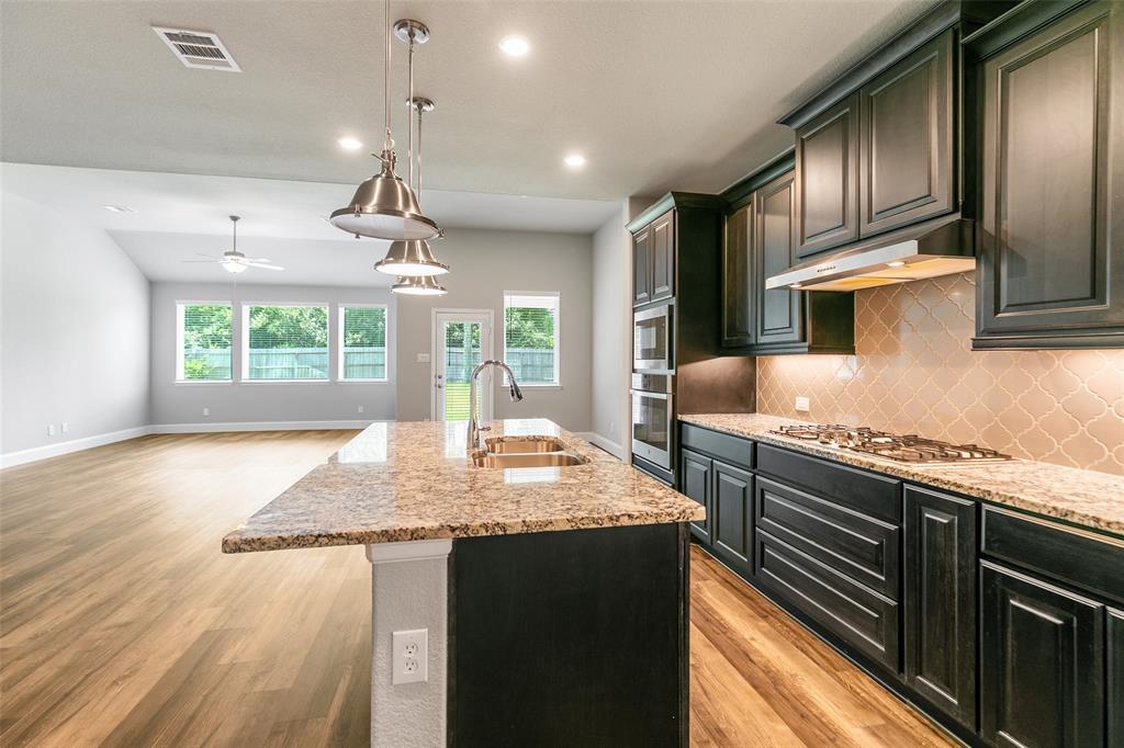 a kitchen with stainless steel appliances granite countertop sink stove top oven and cabinets