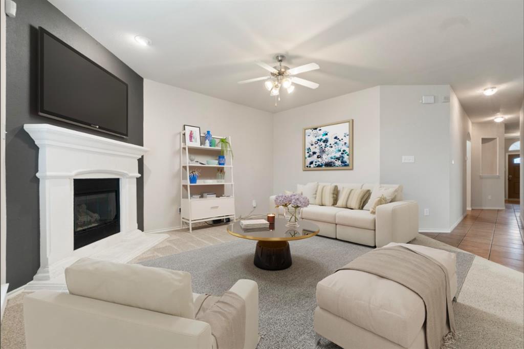 a living room with furniture a flat screen tv and a fireplace