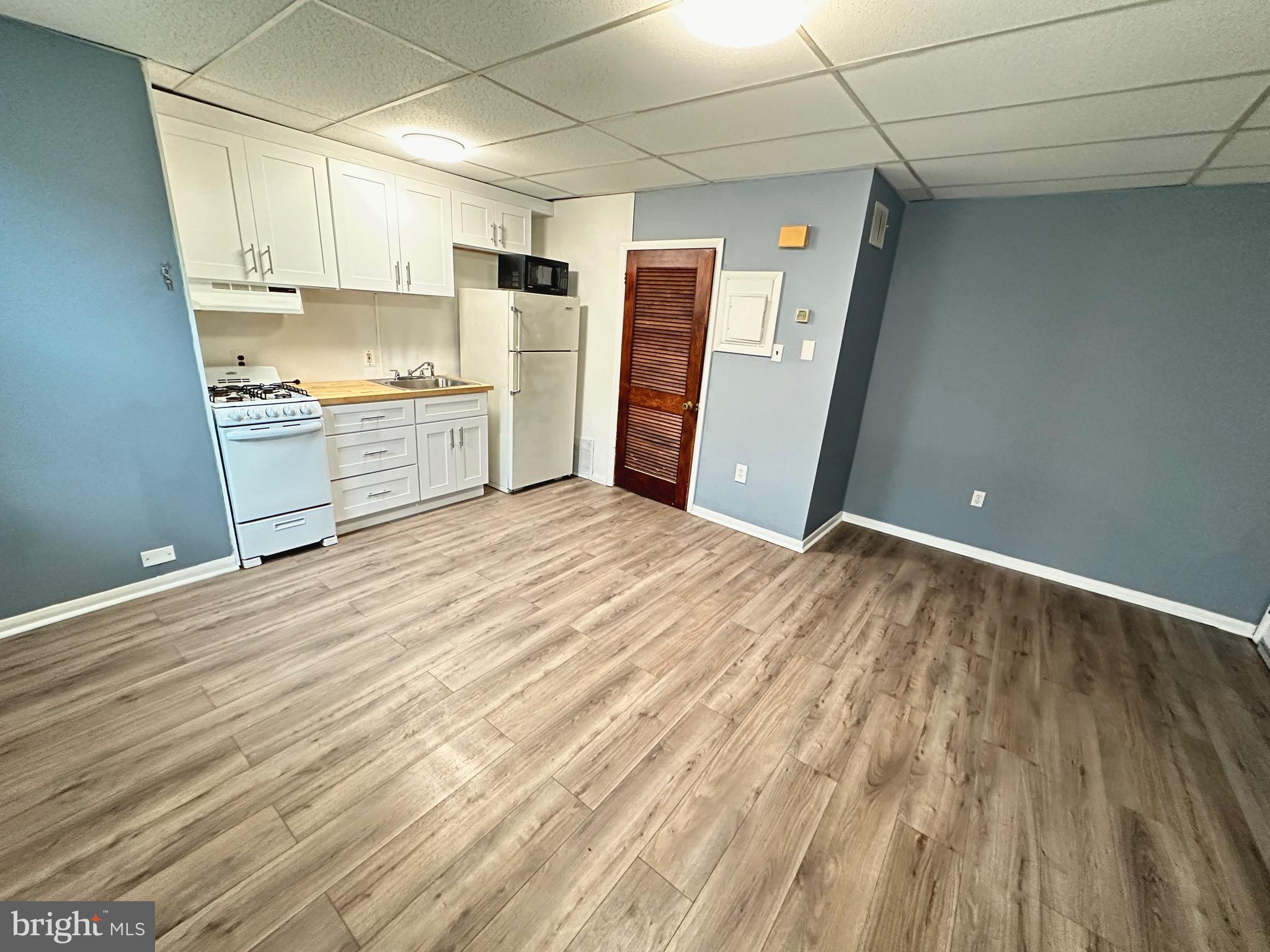 a view of a kitchen with wooden floor and electronic appliances