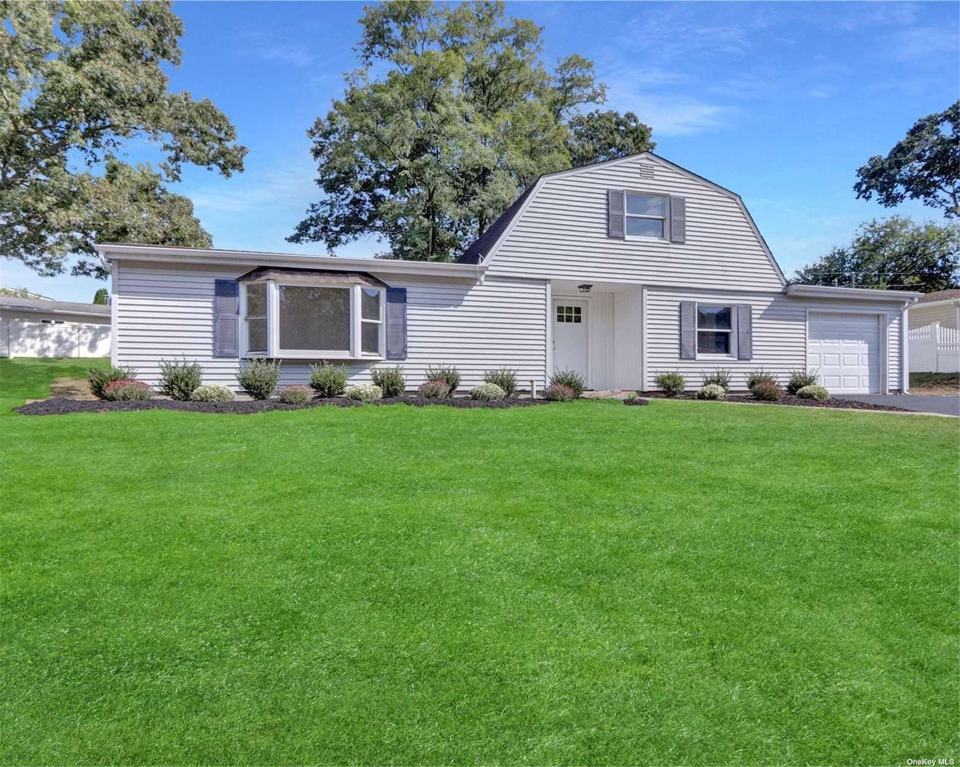 a front view of a house with a yard and trees