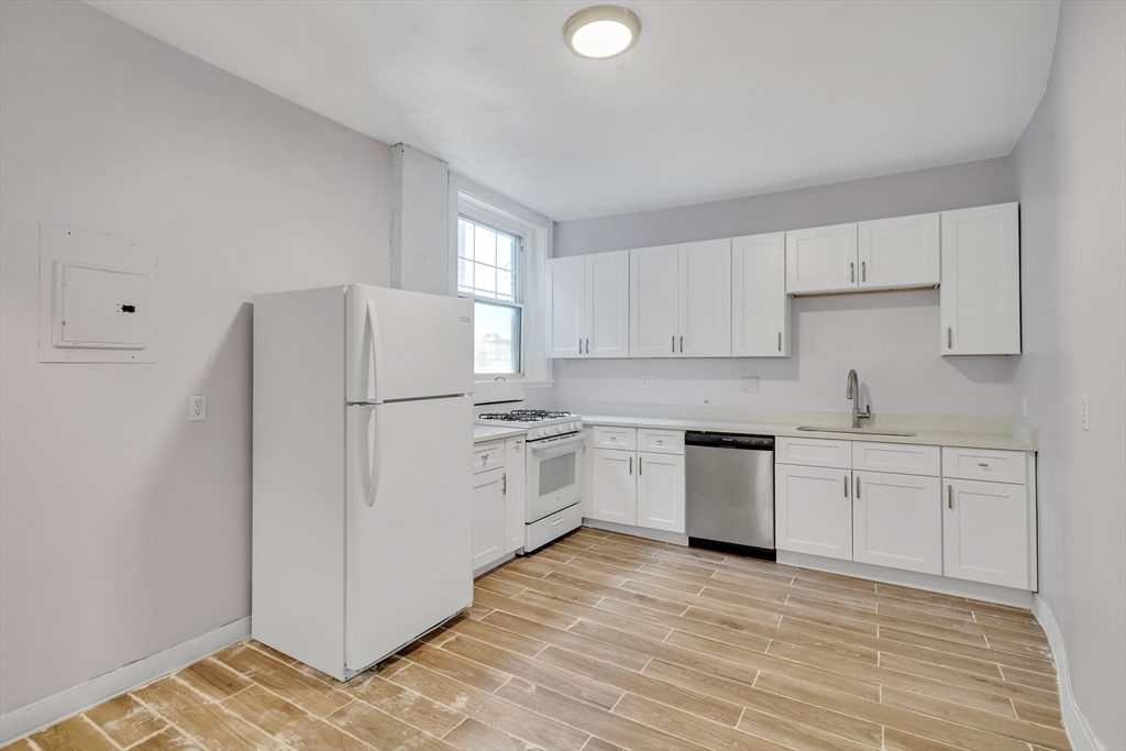 a kitchen with white cabinets and white appliances