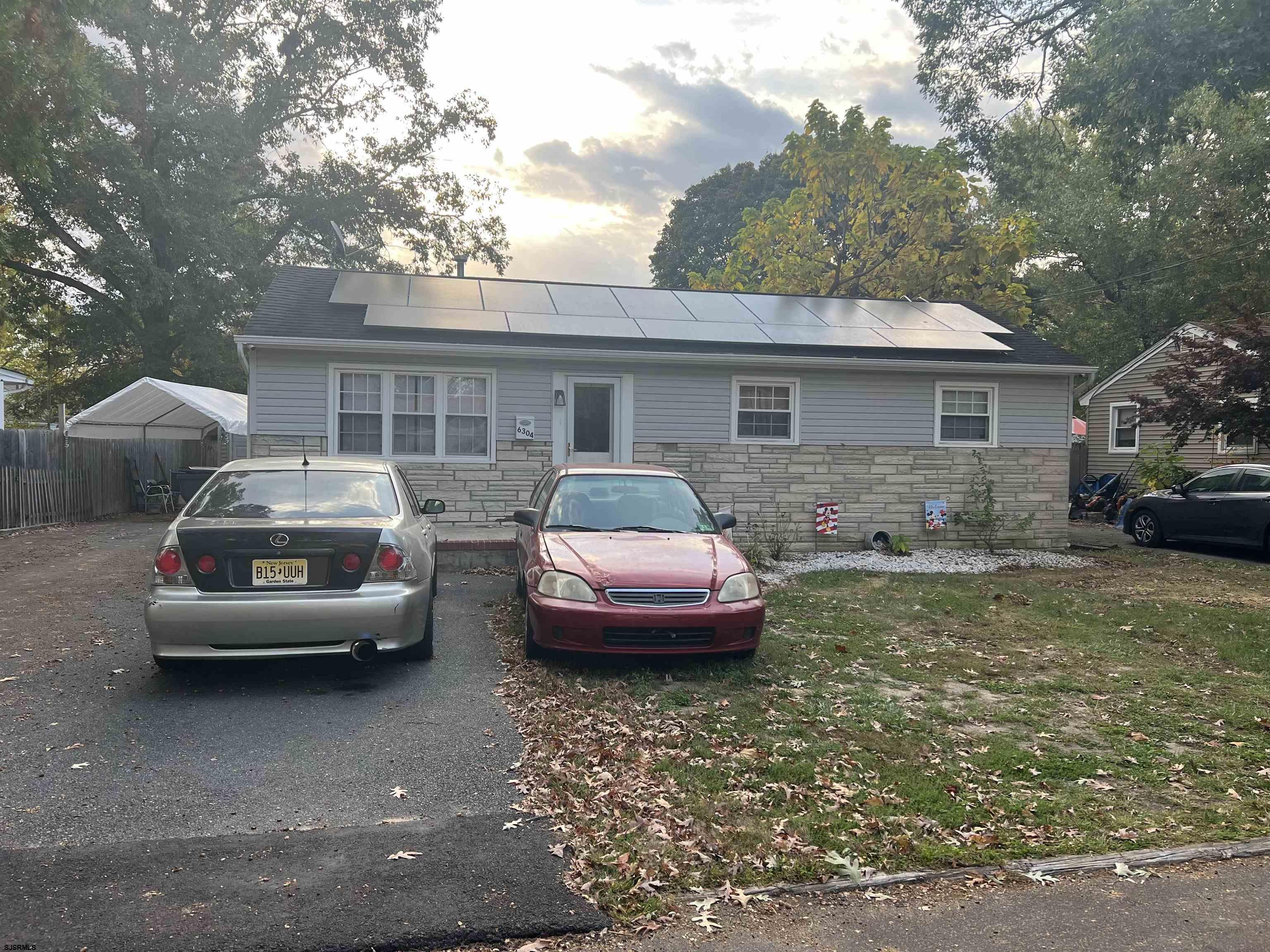 a front view of a house with cars parked