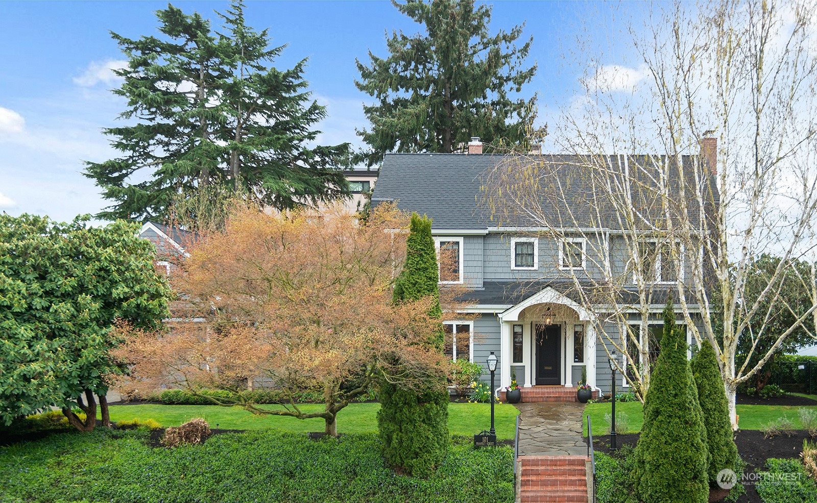 a front view of a house with a garden and plants