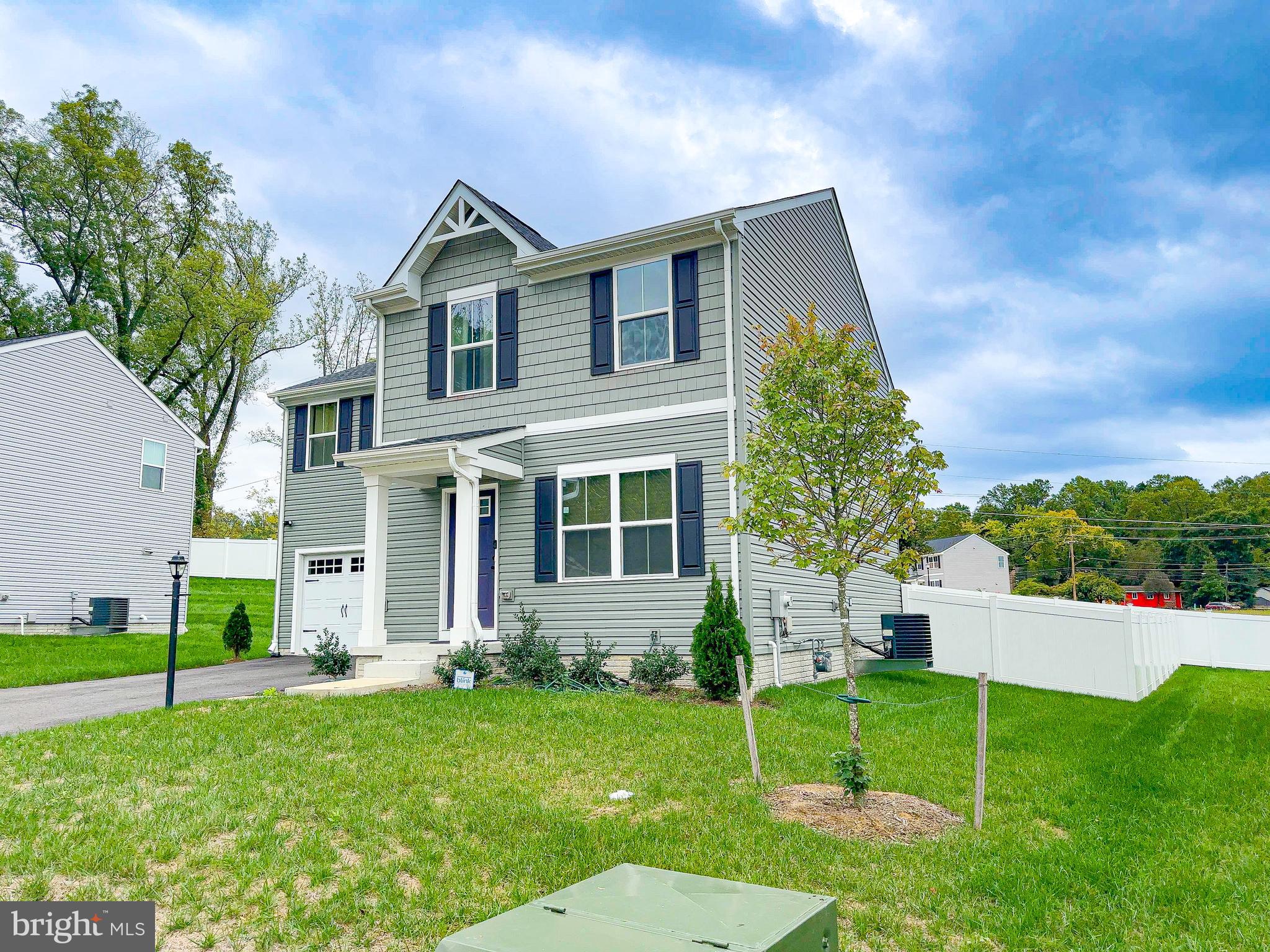 a front view of a house with a yard and trees