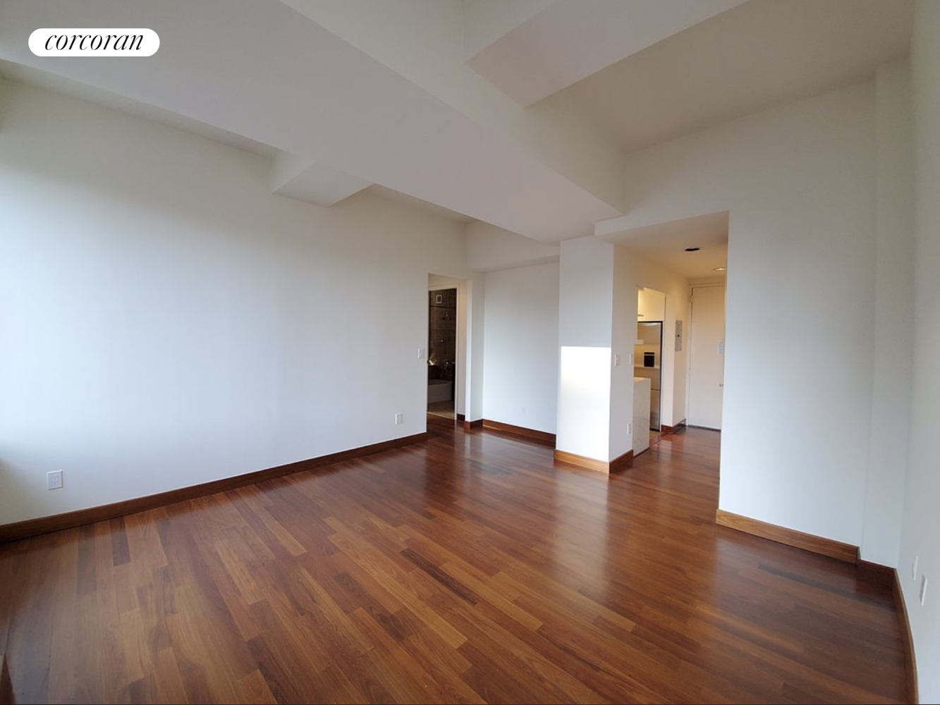 a view of an empty room and wooden floor