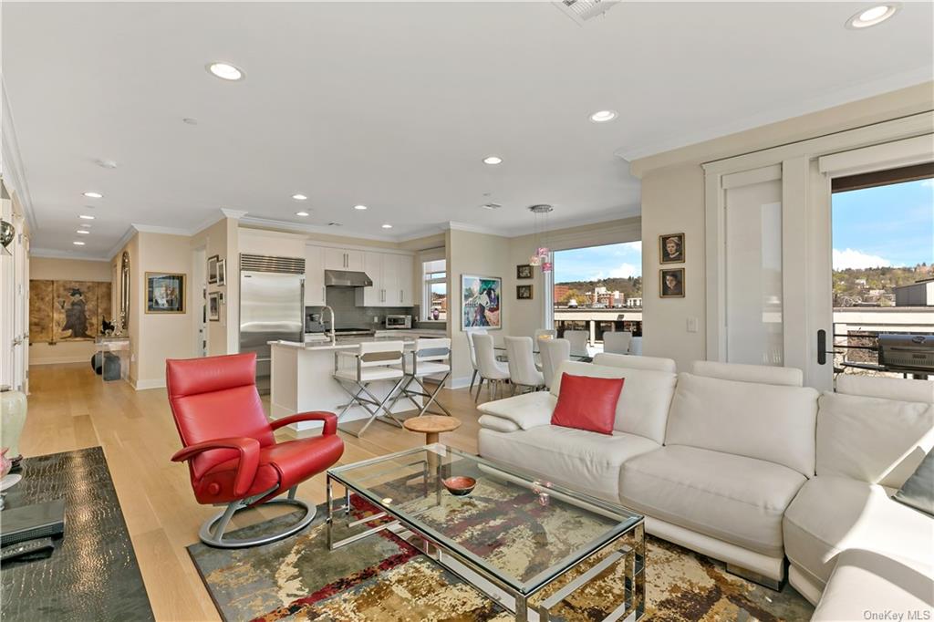 a living room with furniture kitchen view and a large window