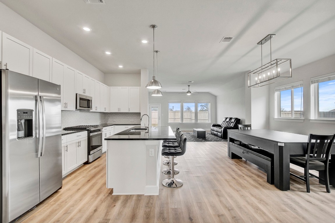 a kitchen with counter top space a sink appliances and cabinets