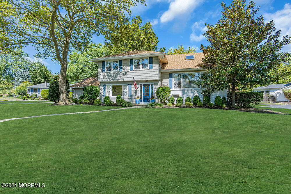 a view of a big house with a big yard and large trees