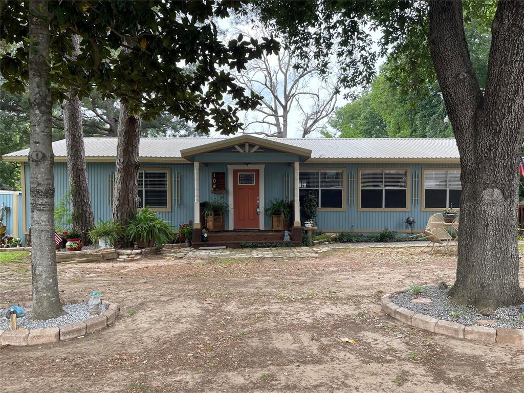 a front view of a house with a tree in front