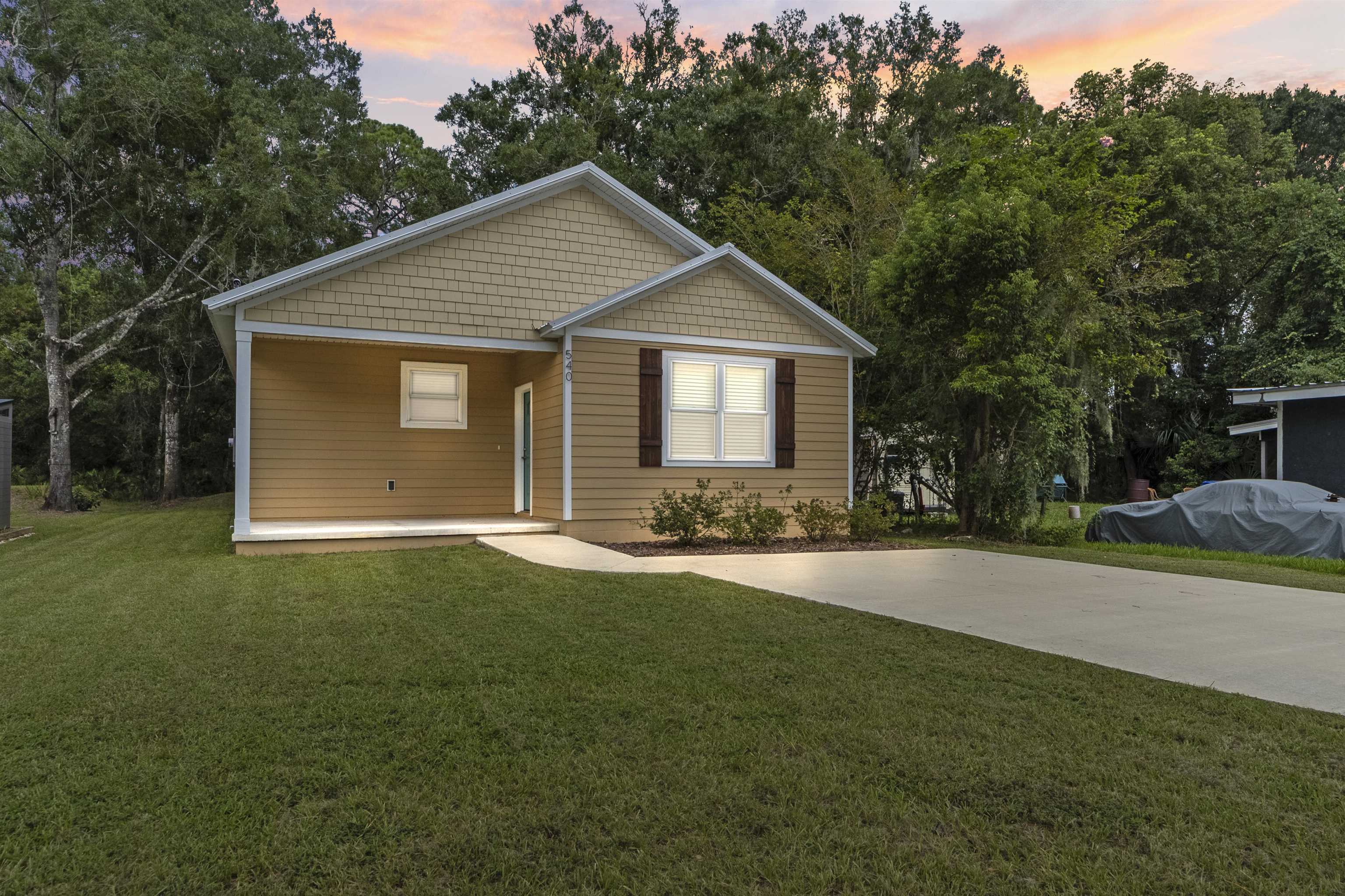 a front view of house with yard and trees