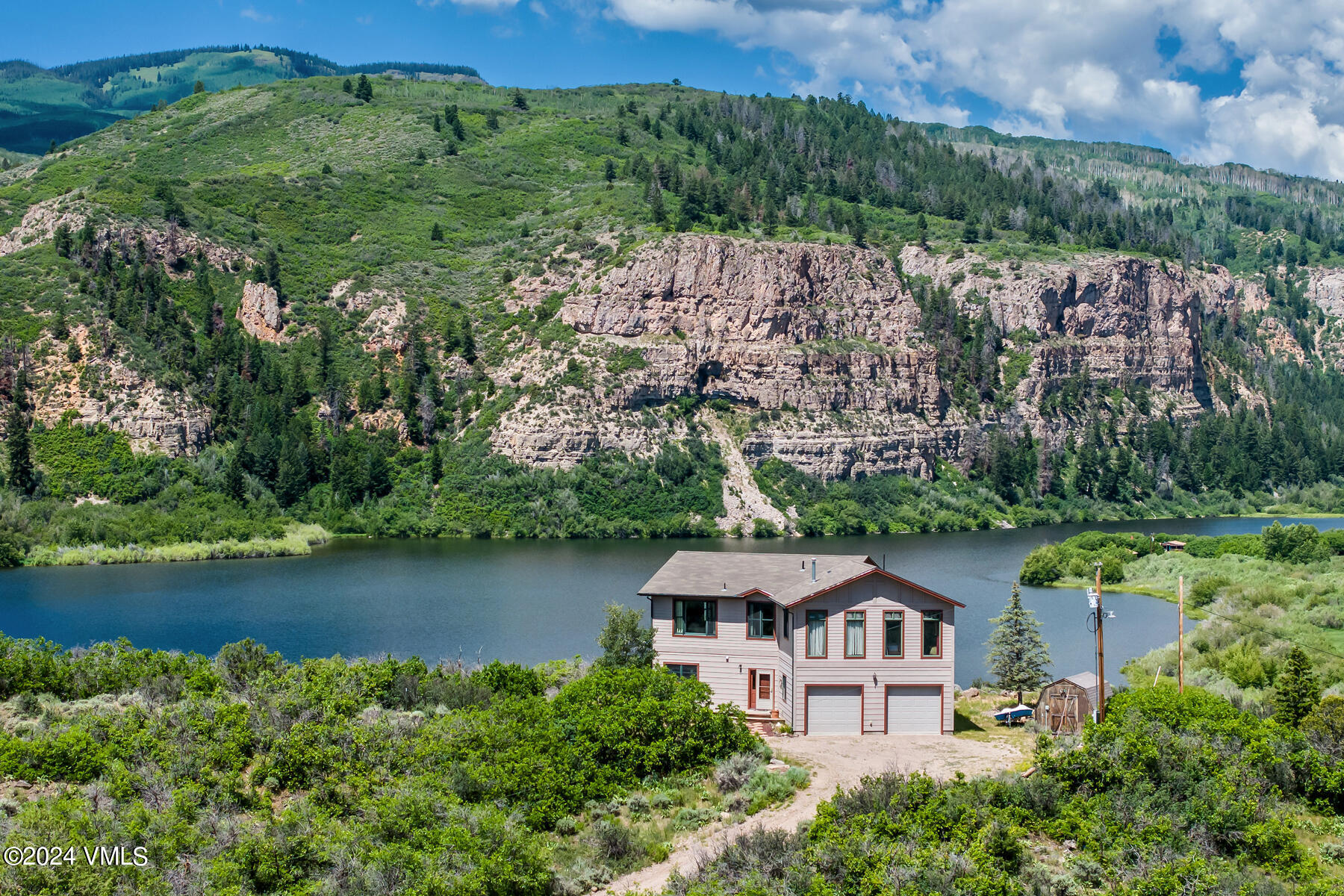 an aerial view of a house with a garden and lake view