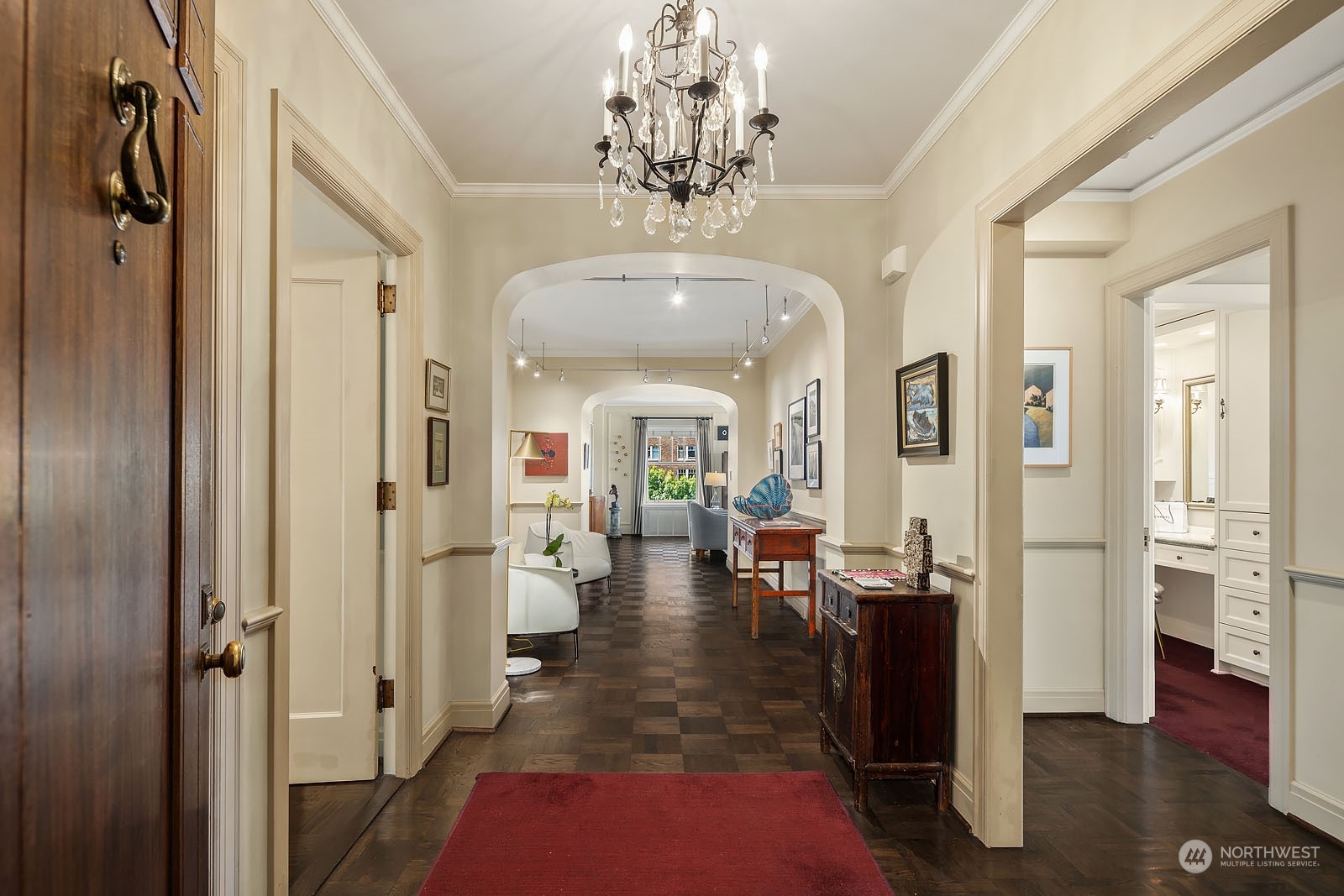 a view of a hallway with living room and couches