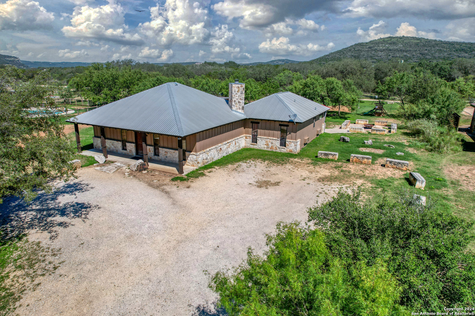 an aerial view of house with yard and mountain view in back