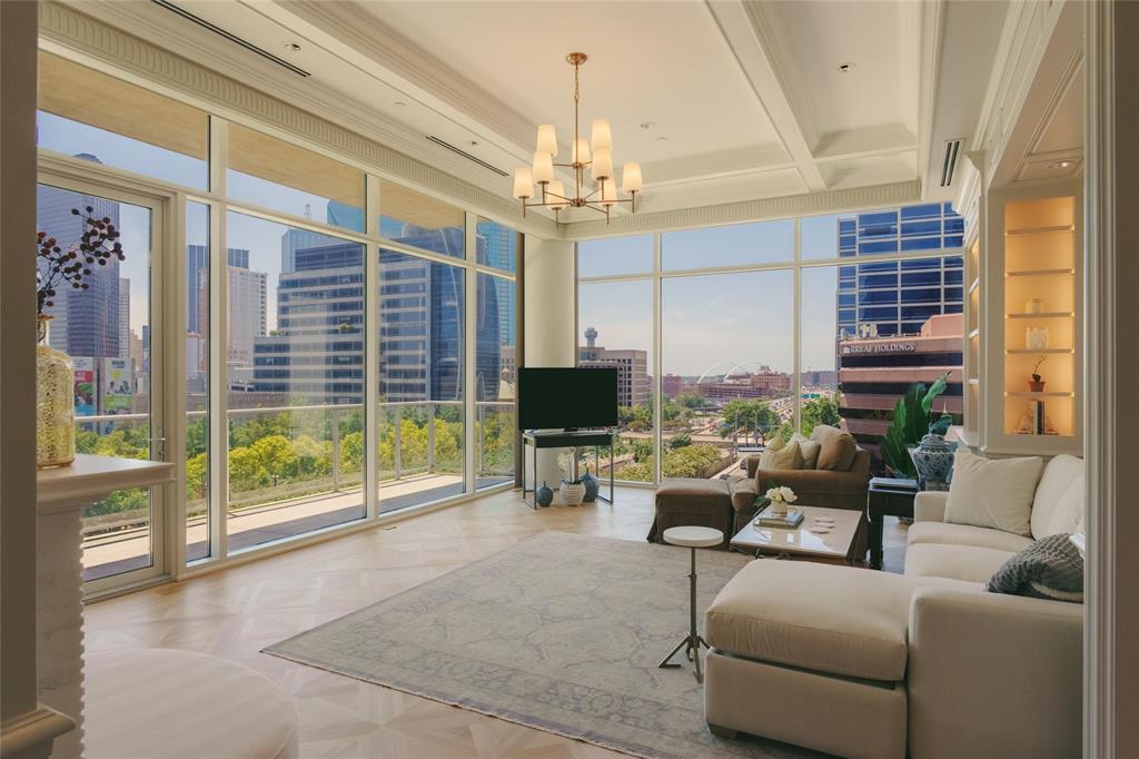 a living room with furniture a large window and a chandelier