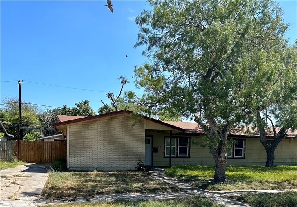 a view of a house with a tree in front of it