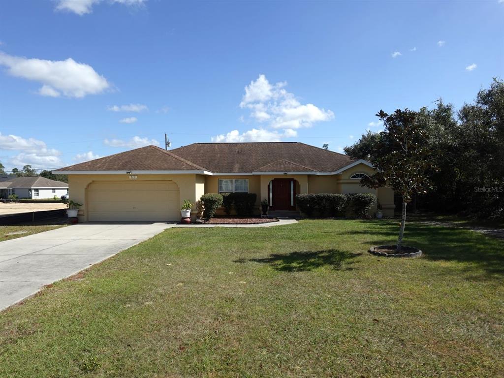 a view of a house with a yard and a garage