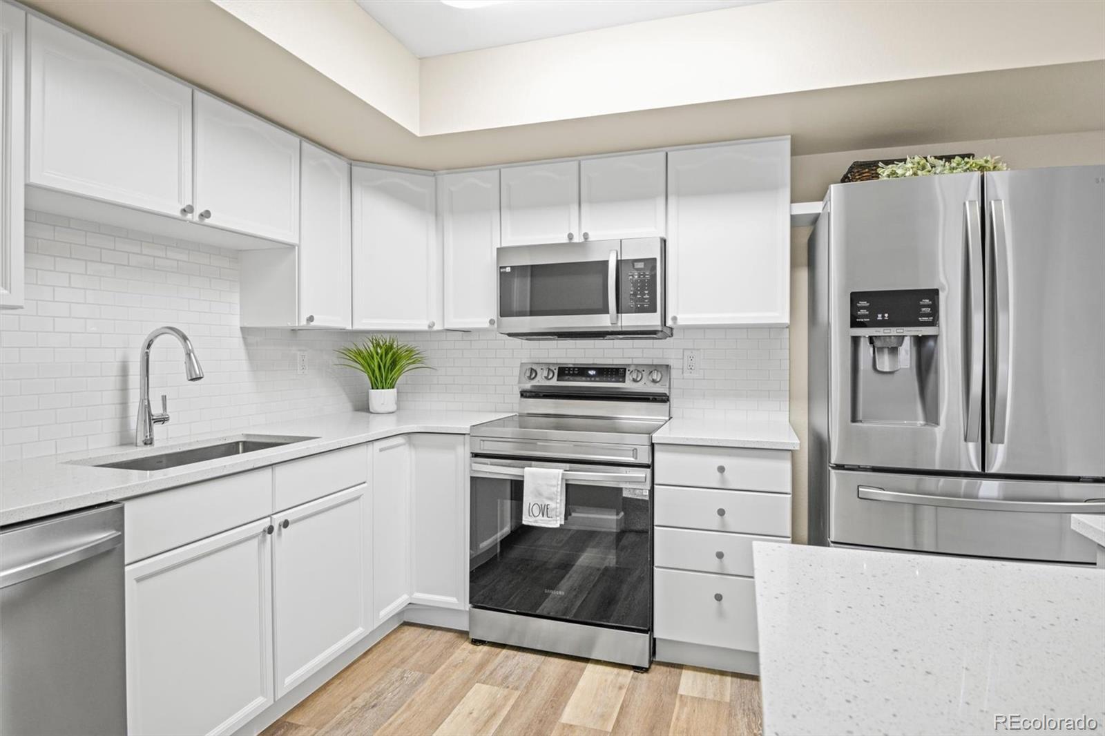 a kitchen with cabinets stainless steel appliances and a counter space