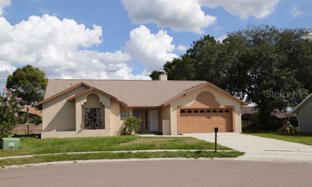 a front view of a house with a garden and trees