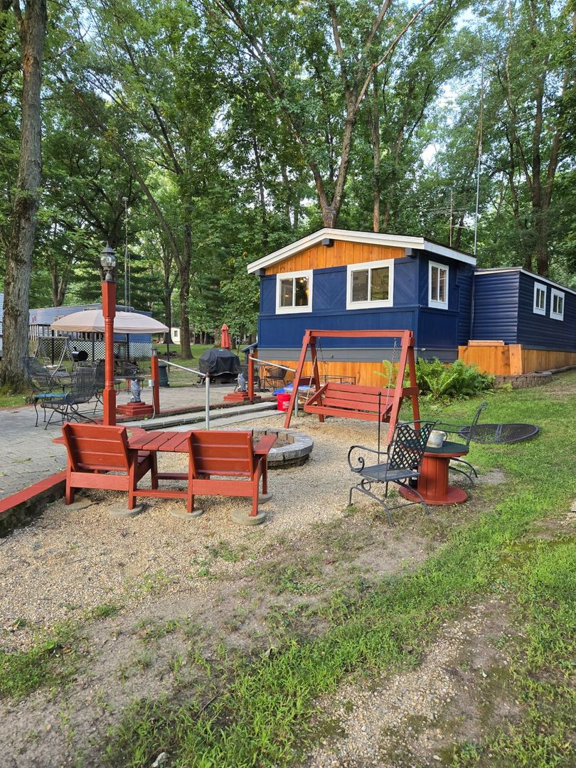 a backyard of a house with fire pit and outdoor seating