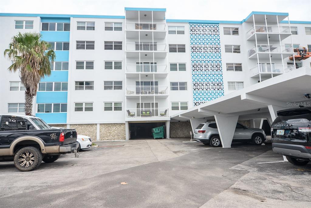 a view of a car and a car parked in front of a building