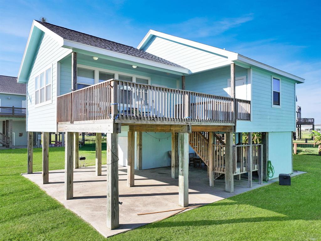 a view of a house with a yard balcony and wooden fence