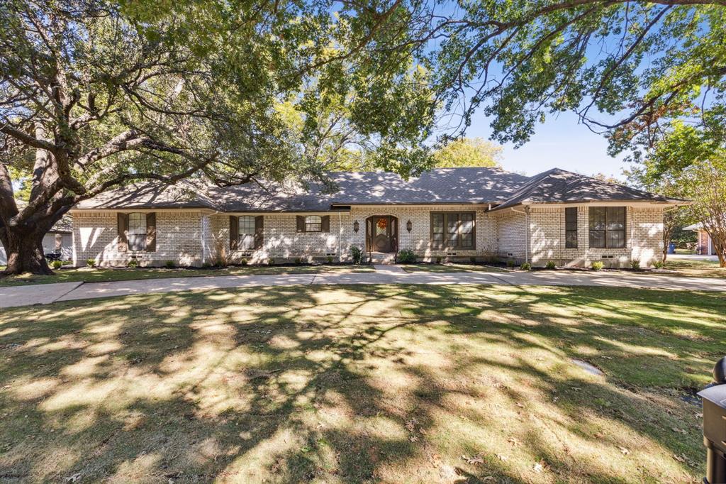 a front view of a house with a yard tree and wooden fence