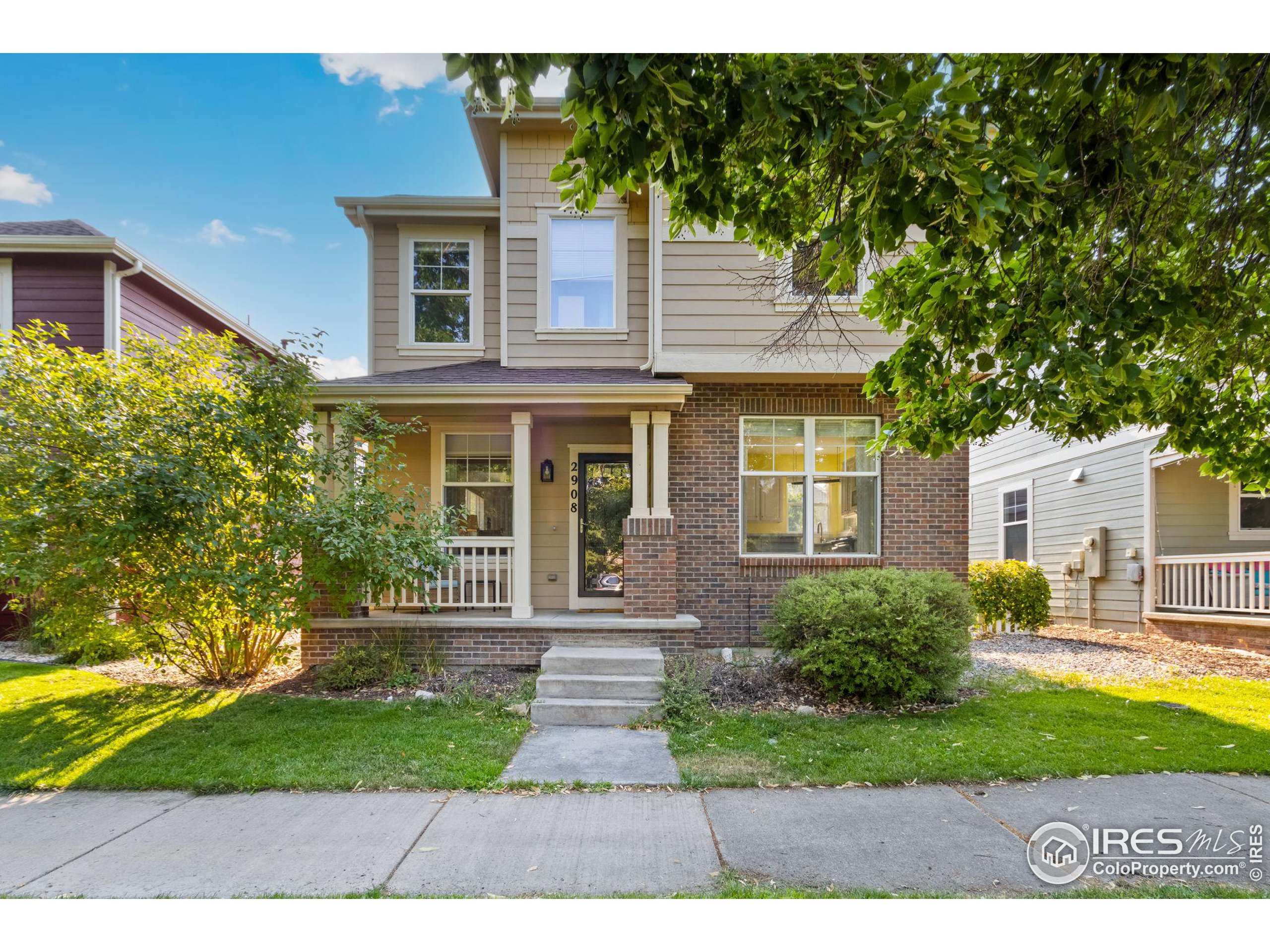 a front view of a house with a yard and potted plants