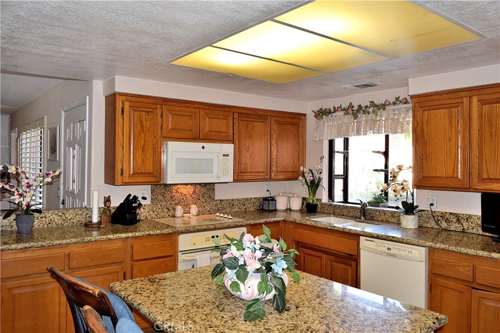 a kitchen with granite countertop lots of counter top space and living room