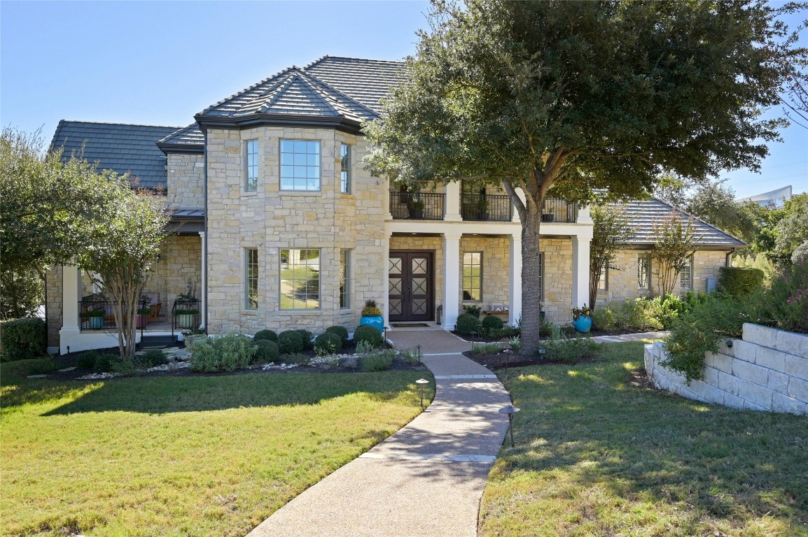 a front view of a house with yard and green space