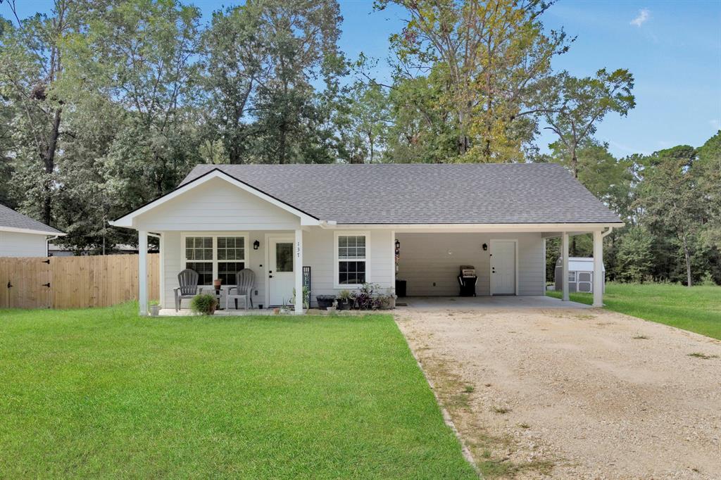 a front view of a house with a yard and trees