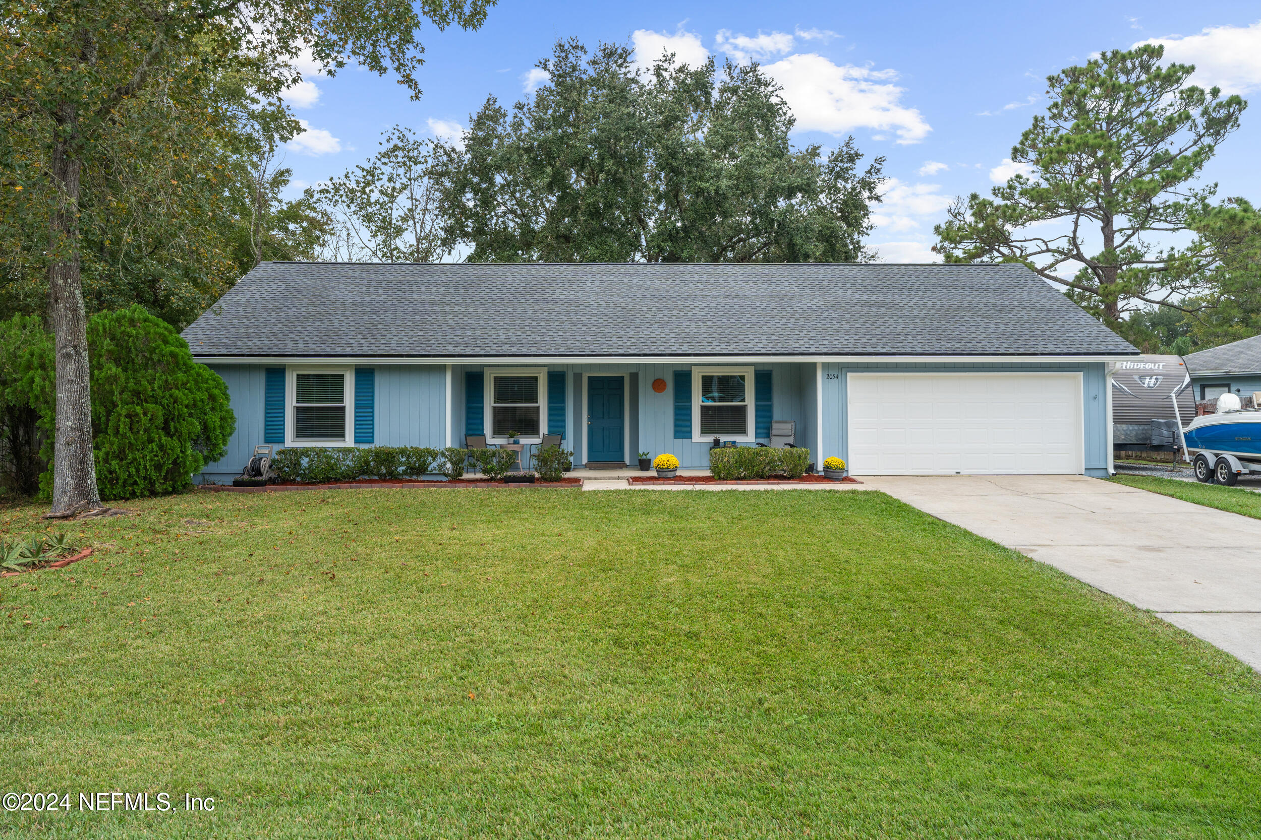 a view of a house with a yard and tree s