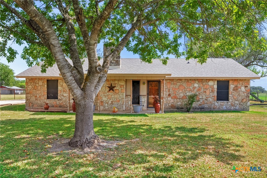 a front view of a house with a garden and trees