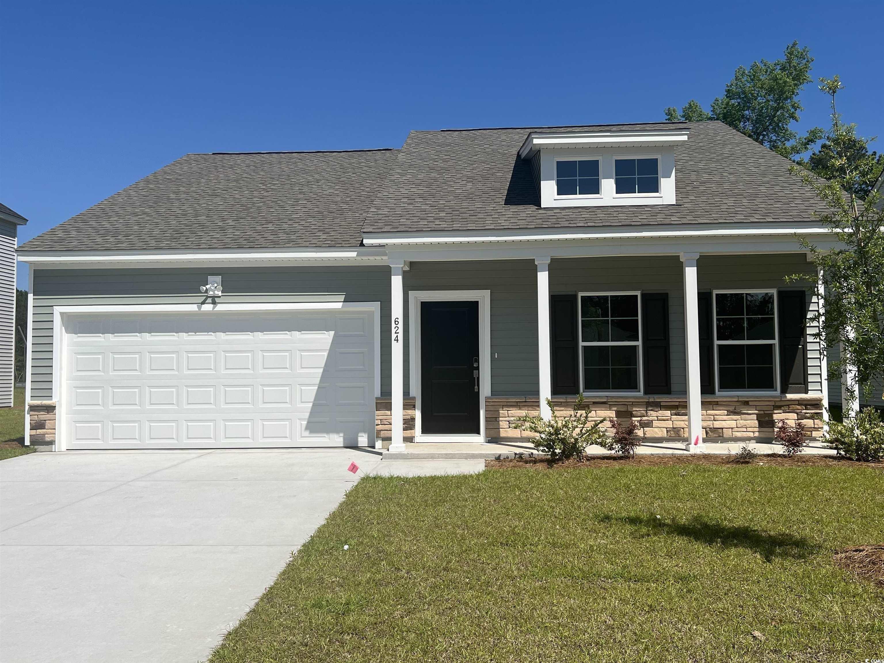 View of front of house with covered porch, a garag