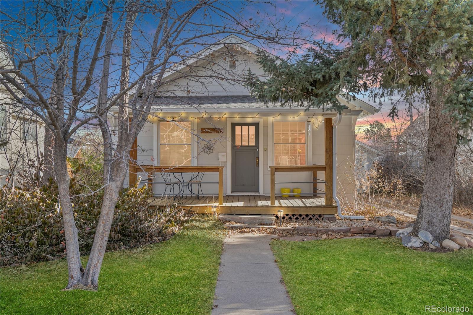 a front view of a house with a garden and trees