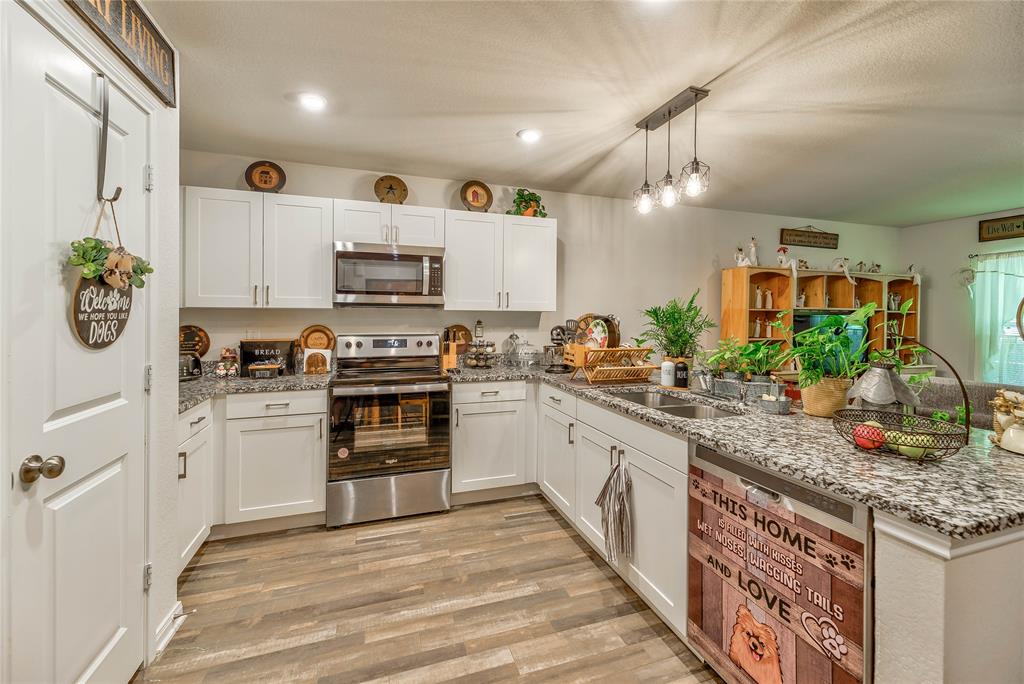 a kitchen with stainless steel appliances granite countertop a stove and cabinets