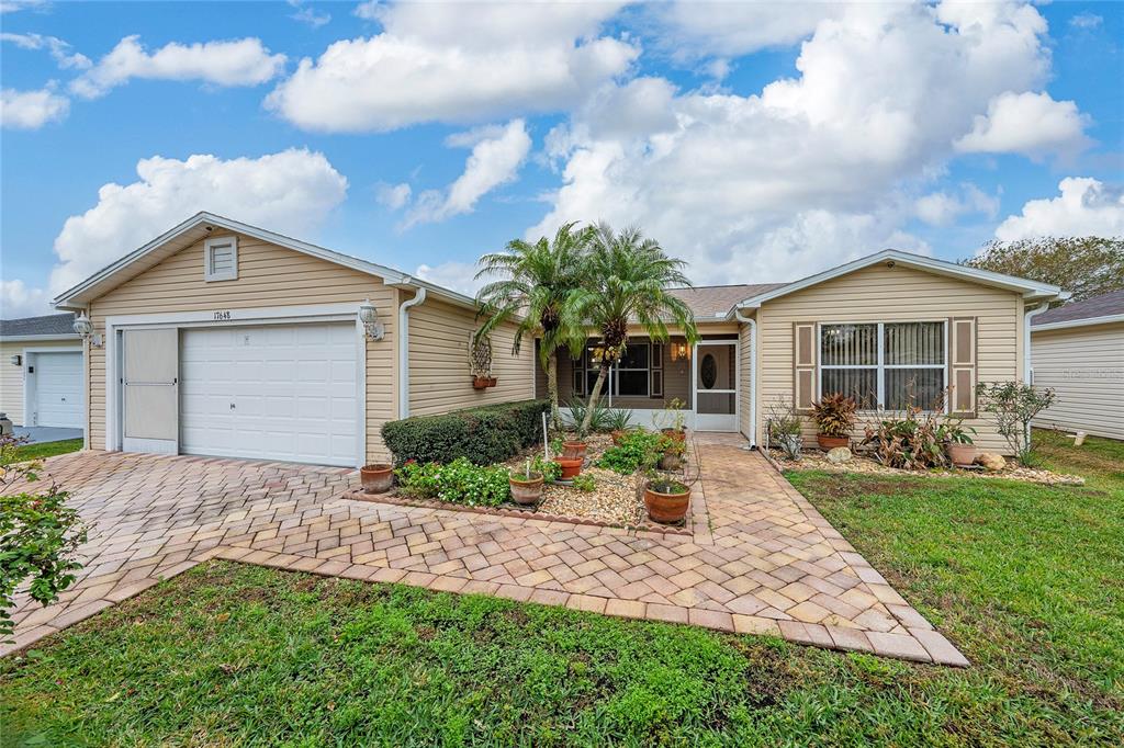 Driveway leads to 2-car garage with sliding screen. Walkway entrance to screened porch.