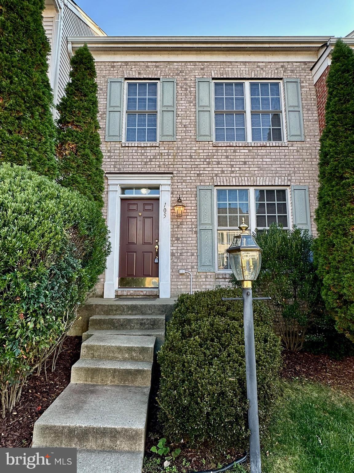 a front view of a house with plants and garden