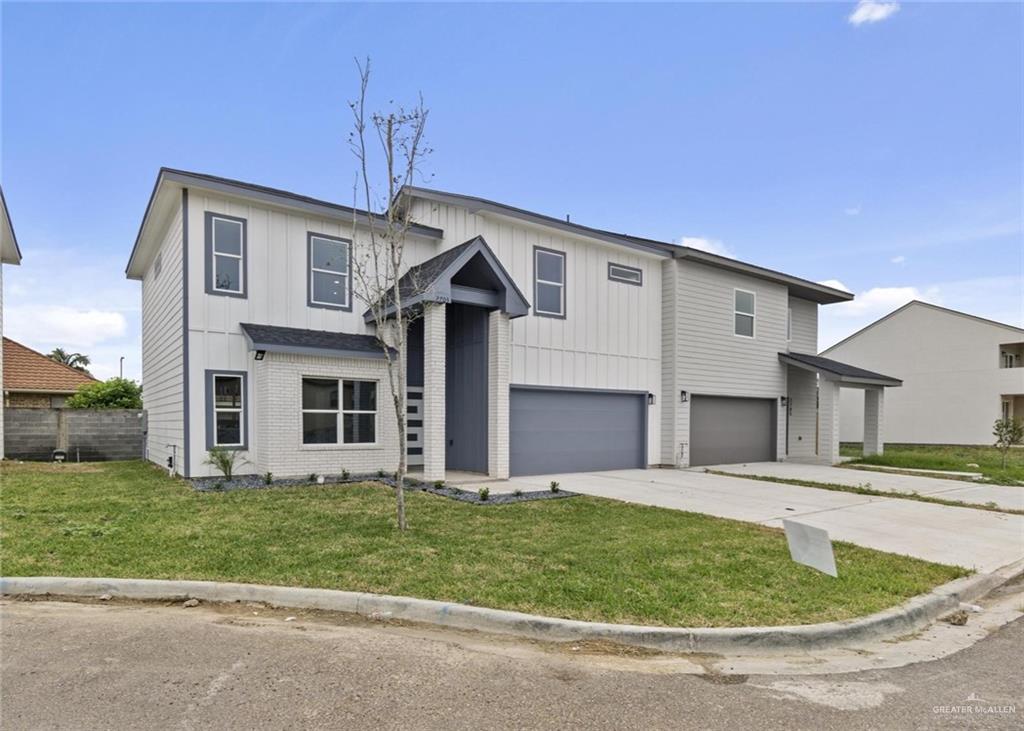 View of front of house featuring a front lawn and a garage